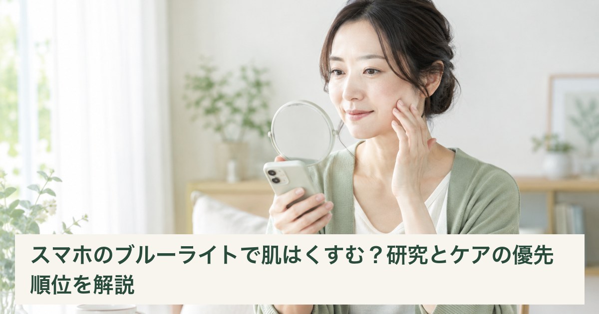 スマートフォンを手元に持ち、鏡で頬の様子を確認する女性