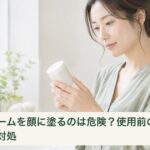 クリームを顔に使う前に、容器の使用方法を確認する女性
