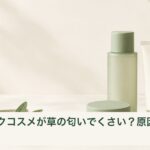 無地の化粧品容器と緑の葉を別々に配置した、草のような香りのイメージ写真