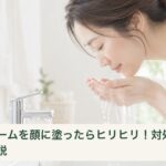 洗面台で水を手に受け、顔をやさしく洗い流そうとする女性